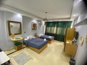 a bedroom with two beds and a television in it at Three pyramids view INN in Cairo