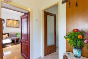 una sala de estar con una puerta y un jarrón de flores en Holiday house with a swimming pool Vinez, Labin - 22240, en Vinež