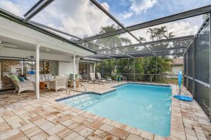 an indoor swimming pool with an open patio and a house at Fort Myers Home, Lanai and Private, Heated Pool in Fort Myers
