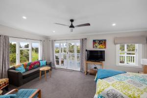 a bedroom with a bed and a couch at Harbour View in Kohukohu Town District
