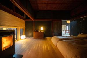 een slaapkamer met een bed en een open haard. bij 古民家宿コロク-Kominka Stay Koroku- in Fujimi