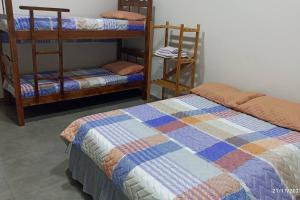 a bedroom with two bunk beds with a quilt at Recanto Matheus Casa de Temporada Olímpia SP in Olímpia +37 photos