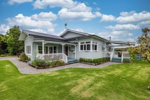 a white house with a yard at Harbour View in Kohukohu Town District