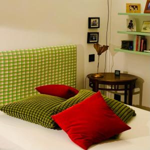 a bed with two red pillows and a table at Apart Deluxe Casa Boffa-Costa in Turin