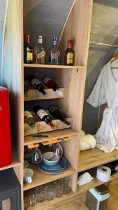 a wooden cabinet with bottles of alcohol and dishes at Glamping La Cepa GUATAPÉ in Guatapé