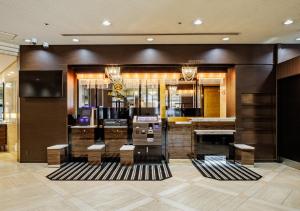 a lobby with a bar with chairs and a television at APA Hotel Kokura Ekimae in Kitakyushu