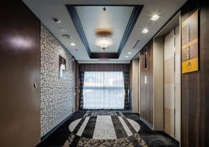 a hallway with a large window and a room with a rug at APA Hotel Kokura Ekimae in Kitakyushu