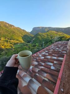 una persona sosteniendo una taza de café en el techo en Azienda Agricola Ausono, en Piaggine