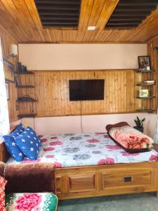 a bedroom with a bed with a tv on the wall at Eviana homestay in Darjeeling