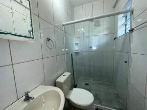 a bathroom with a shower and a toilet and a sink at Pousada Suíte Verde Mar in Ubatuba