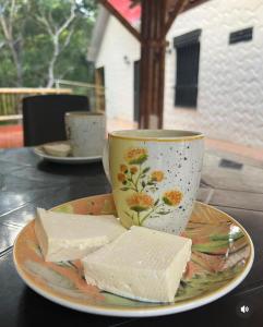 un plato de queso y una taza sobre una mesa en Cabañas Monteleón Paicol- Huila en La Laja