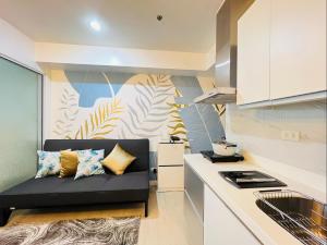 ein Wohnzimmer mit einem Sofa in der Küche in der Unterkunft Lovely and Refreshing 1BR Suite in Manila