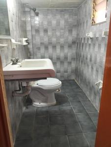 a bathroom with a toilet and a sink at Hotel Beatriz in Acapulco