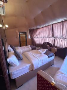 una camera con due letti e un divano di Nara desert camp a Wadi Rum
