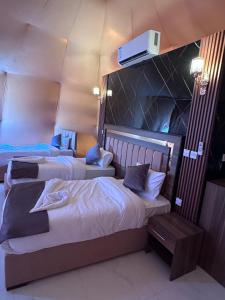 una camera d'albergo con due letti e una TV a parete di Nara desert camp a Wadi Rum