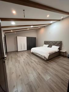 a large bedroom with a bed and a wooden floor at Moonlight in Taif