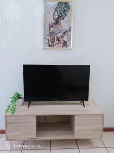 ボクスブルクにあるApartment in Boksburg near OR TAMBO INTERNATIONAL AIRPORTの木製エンターテイメントセンターの上に座って薄型テレビを設置