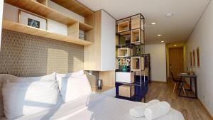 1 dormitorio con 1 cama grande con almohadas blancas en Apartasuites Cabrera 85, en Bogotá