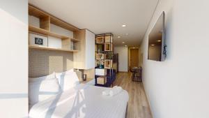 1 dormitorio con 1 cama y TV en la pared en Apartasuites Cabrera 85, en Bogotá