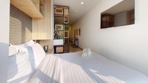 a bedroom with a white bed with white shoes on it at Apartasuites Cabrera 85 in Bogotá