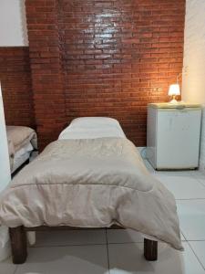 uma cama num quarto com uma parede de tijolos em Aires de Vida em Federación