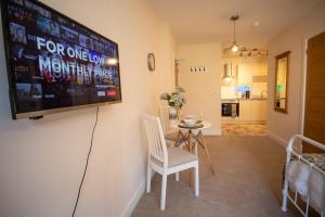 a living room with a tv and a table and chairs at Tranquility Short & Long stays in Eastbourne