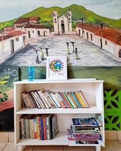 a book shelf with a painting of penguins on it at Hostal Sol y Luna 