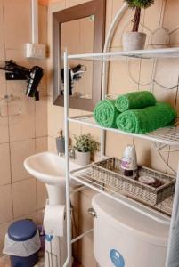 ein Badezimmer mit einem Waschbecken, einem WC und einem Spiegel in der Unterkunft Hostal Sol y Luna 
