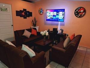 ein Wohnzimmer mit 2 Sofas und einem Flachbild-TV in der Unterkunft Hostal Sol y Luna 