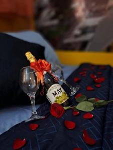 a wine glass with a bottle and roses on a table at Hostal Sol y Luna 