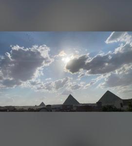 uma vista das pirâmides de Gizé sob um céu nublado em 4 Pyramids inn no Cairo