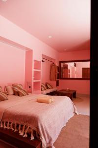 una camera da letto con un grande letto e pareti rosa di VA Villa Jimbaran Bali a Jimbaran