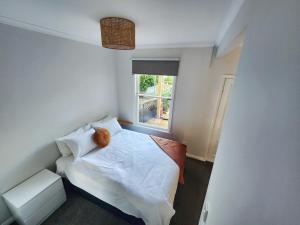 um pequeno quarto com uma cama e uma janela em City Edge Nest em Wellington