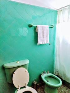 baño verde con aseo y lavamanos en Hospedaje en Salta