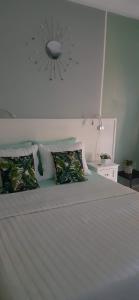 een slaapkamer met een groot wit bed met kussens bij Riverside Apartments in San Juan