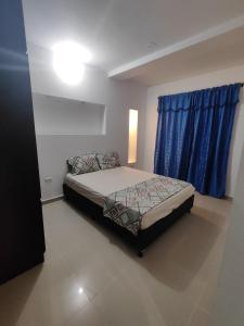 - une chambre avec un lit et une fenêtre bleue dans l'établissement Oceano, à Apartadó