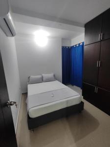 - une chambre avec un lit doté de rideaux bleus dans l'établissement Oceano, à Apartadó