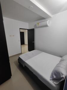 - un lit blanc dans une chambre dotée d'un plafond blanc dans l'établissement Oceano, à Apartadó