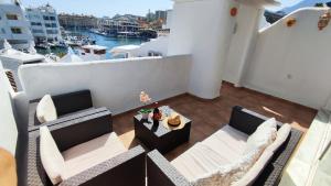 - un balcon avec deux canapés et une table sur le toit dans l'établissement Puerto Marina luxury apartment with sea views, à Benalmádena