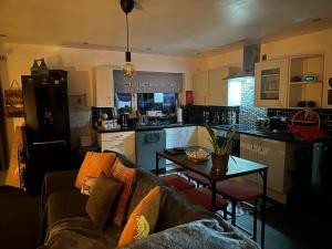 a kitchen and living room with a couch and a table at Shropshire Guesthouse in Wolverhampton