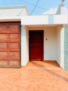 Linda Vista Hostal في ماناغوا: كراج له باب احمر على المنزل