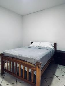 Linda Vista Hostal في ماناغوا: سرير في غرفة بجدار أبيض