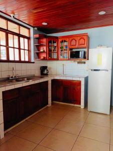 eine Küche mit roten Schränken und einem weißen Kühlschrank in der Unterkunft Linda Vista Hostal in Managua