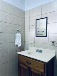 a bathroom with a sink and a mirror at Linda Vista Hostal in Managua