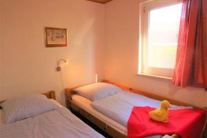 un pato amarillo de goma sentado en una cama en un dormitorio en Möwe 35, en Mirow