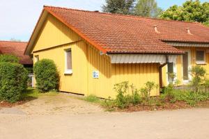 una casa amarilla con techo rojo en Möwe 35, en Mirow