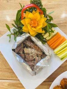 a plate of food with a bouquet of flowers and vegetables at KHÁCH SẠN KIM NHAN in Anh Sơn