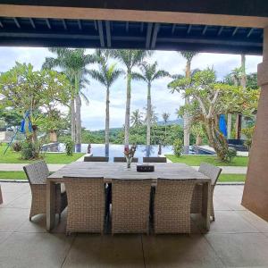 - une table à manger avec des chaises et des palmiers dans l'établissement Villa Tiara, à Senggigi