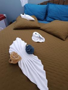 Una cama con toallas y toallas. en la casa mangue en Le Diamant