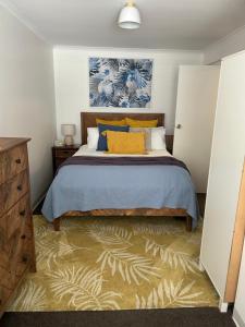 1 dormitorio con 1 cama con almohadas azules y amarillas en Sunshine Five en Salisbury